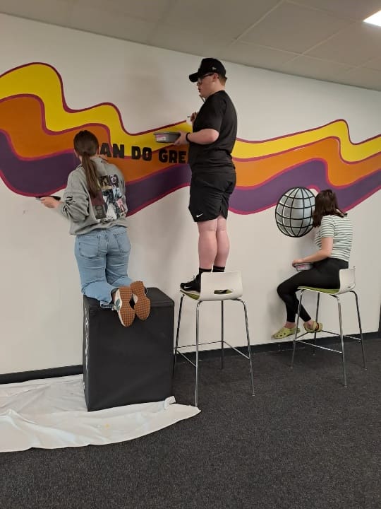 Young people painting a mural